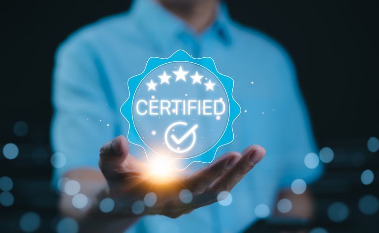 A man is kneeling down to roll out a roll of grass in a garden.