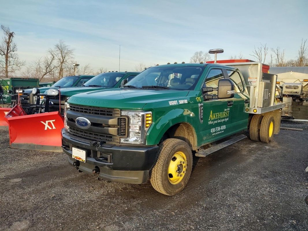 A row of trucks parked next to each other in a parking lot.