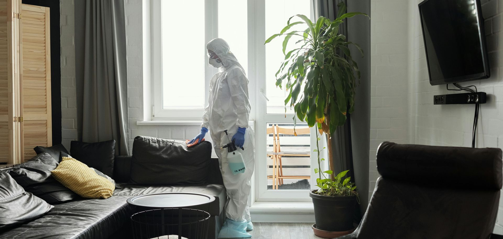 Chambre d'hôtel avec un lit, un petit canapé, une table et un grand miroir reflétant le lit.