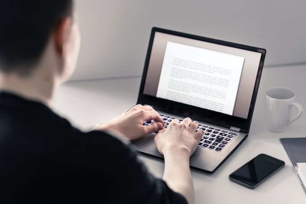 A Man is Typing on a Laptop Computer — Search Partners in Melbourne, VIC