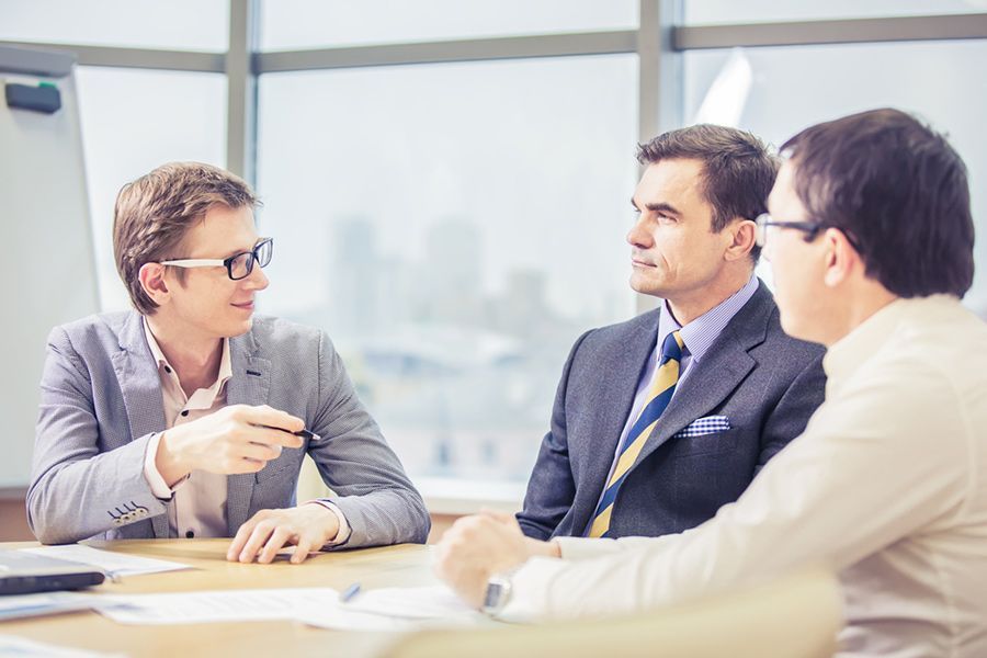 Three Men Are Sitting at a Table Having a Meeting — Search Partners in Melbourne, VIC