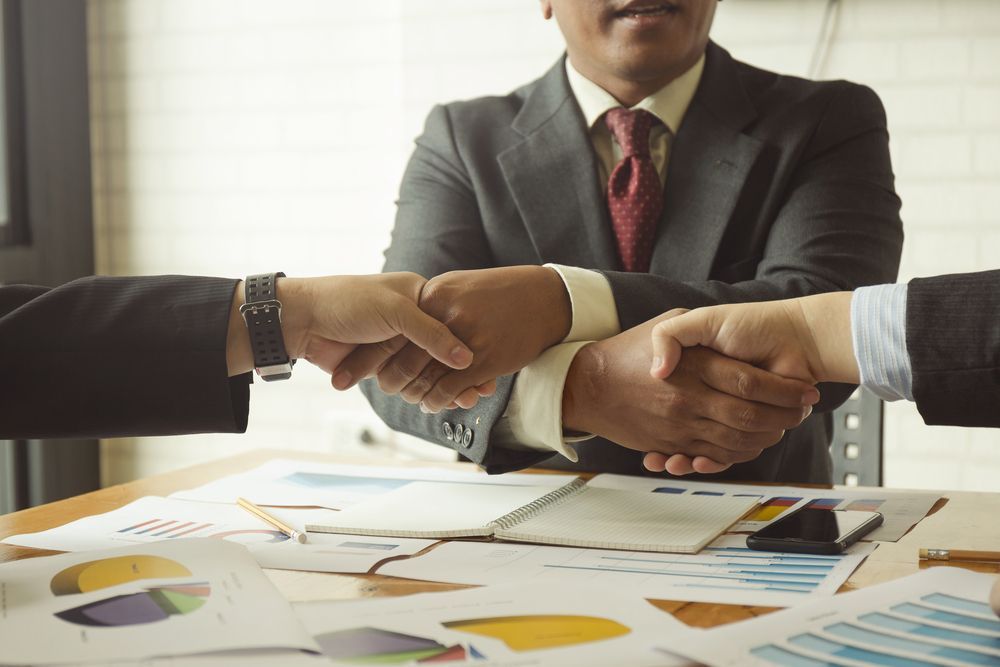 A Group of Business People Shaking Hands Over a Table — Search Partners in Canberra, ACT
