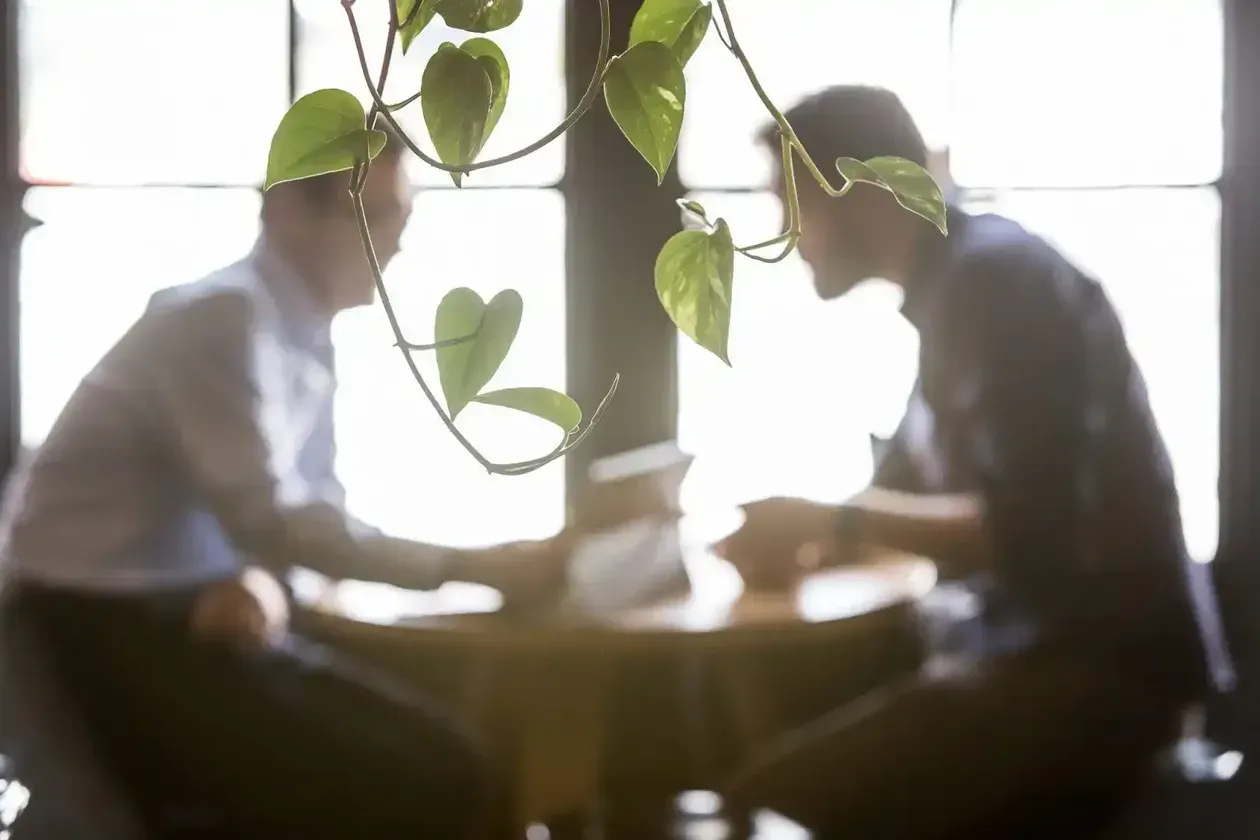 A Group of People Are Sitting Around a Table Shaking Hands — Search Partners in Melbourne, VIC
