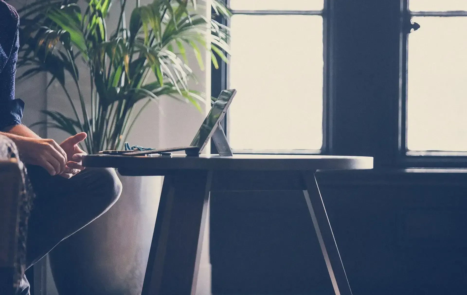 A Man is Sitting at a Table Using a Laptop Computer — Search Partners in Melbourne, VIC
