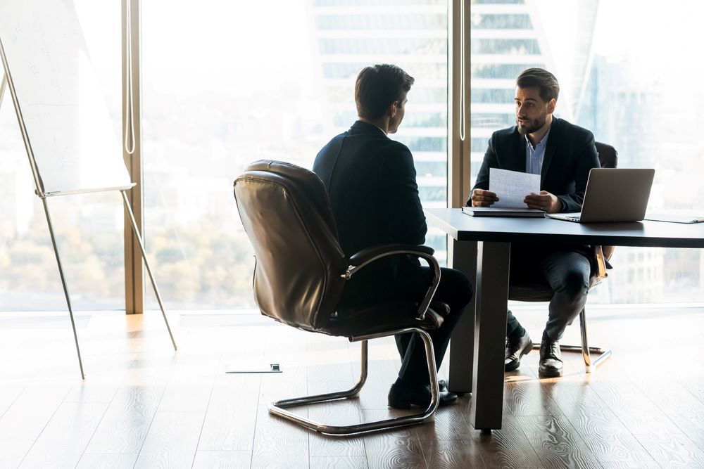 Two Men Are Sitting at a Table Having a Conversation — Search Partners in Perth, WA