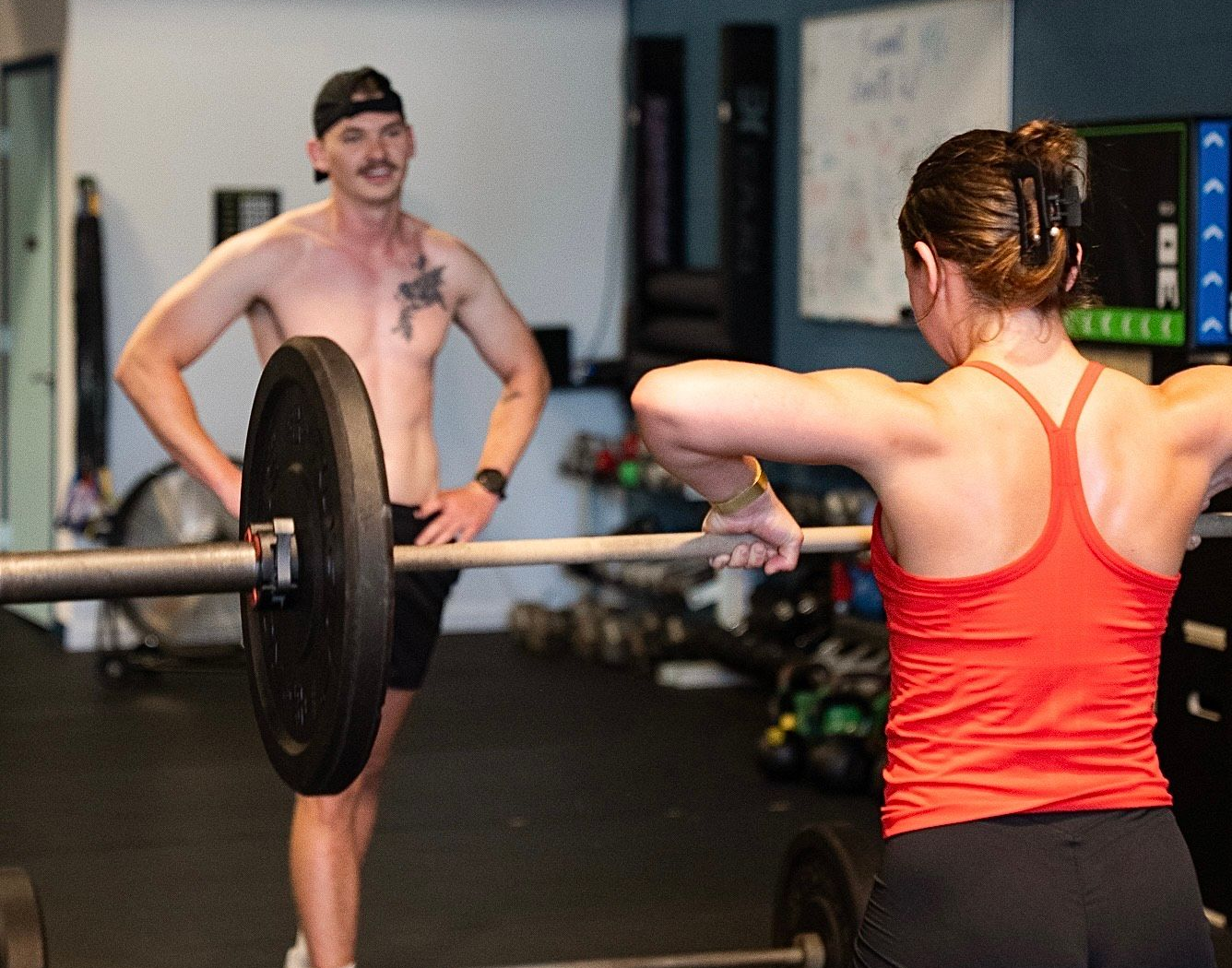Man watches woman lifting weights at CrossFit gym in Asheville, NC