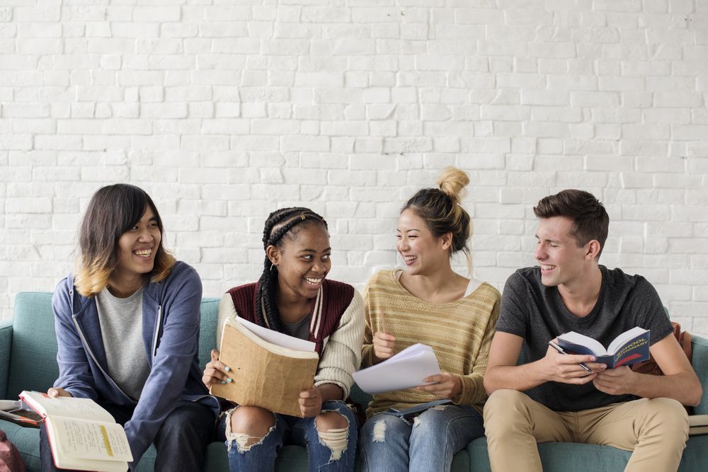 A Group of Young People Are Sitting on a Couch Reading Books — The Molecule Mentor in Lorn, NSW