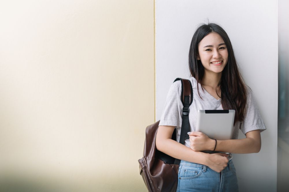 A Young Woman is Standing Next to a Wall Holding — The Molecule Mentor in Lorn, NSW