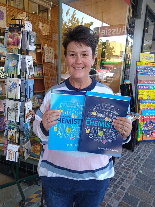 The Molecule Mentor Holding Two Chemistry Books — The Molecule Mentor in Lorn, NSW
