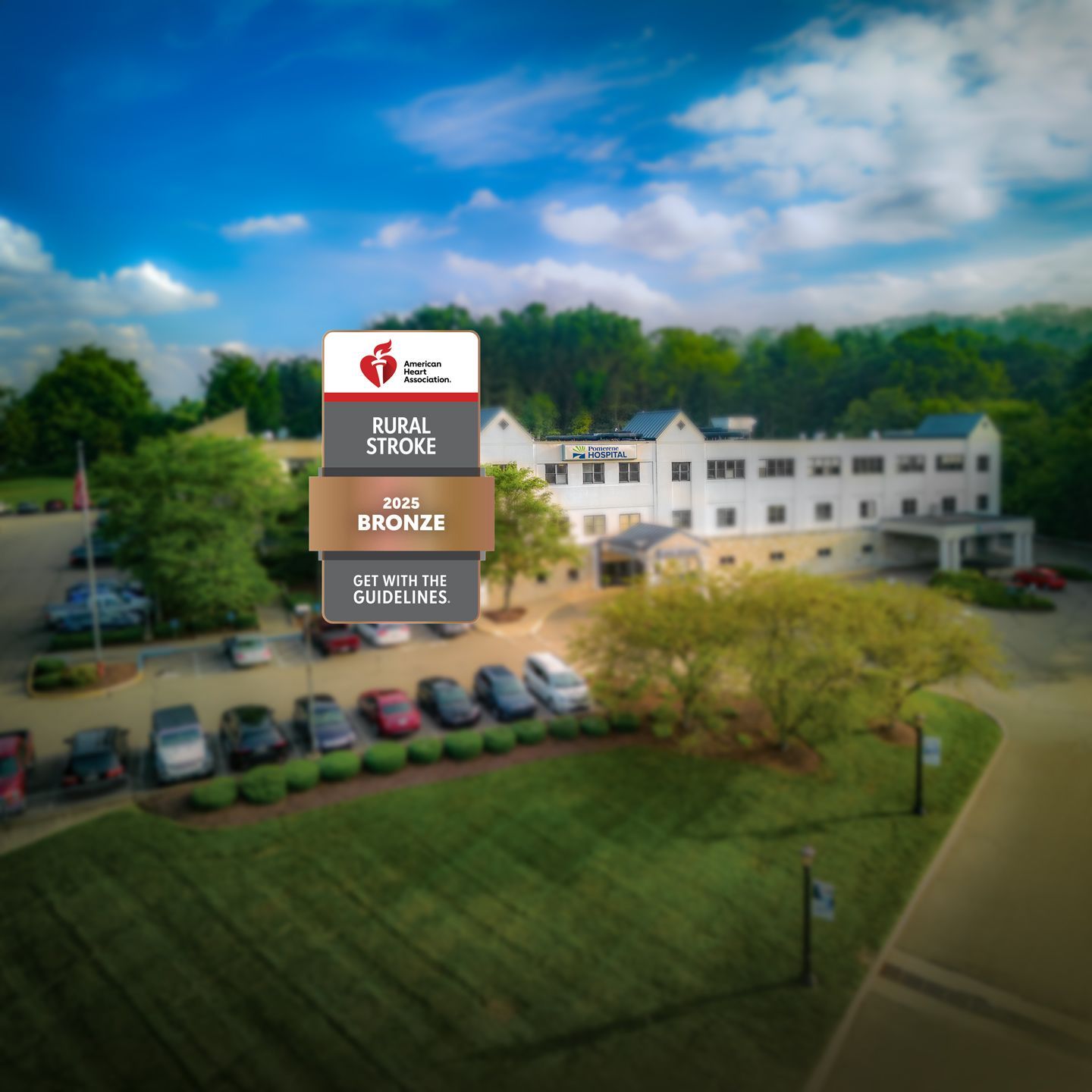 Exterior shot of a building with a sign for a medical clinic. Parking lot filled with cars.