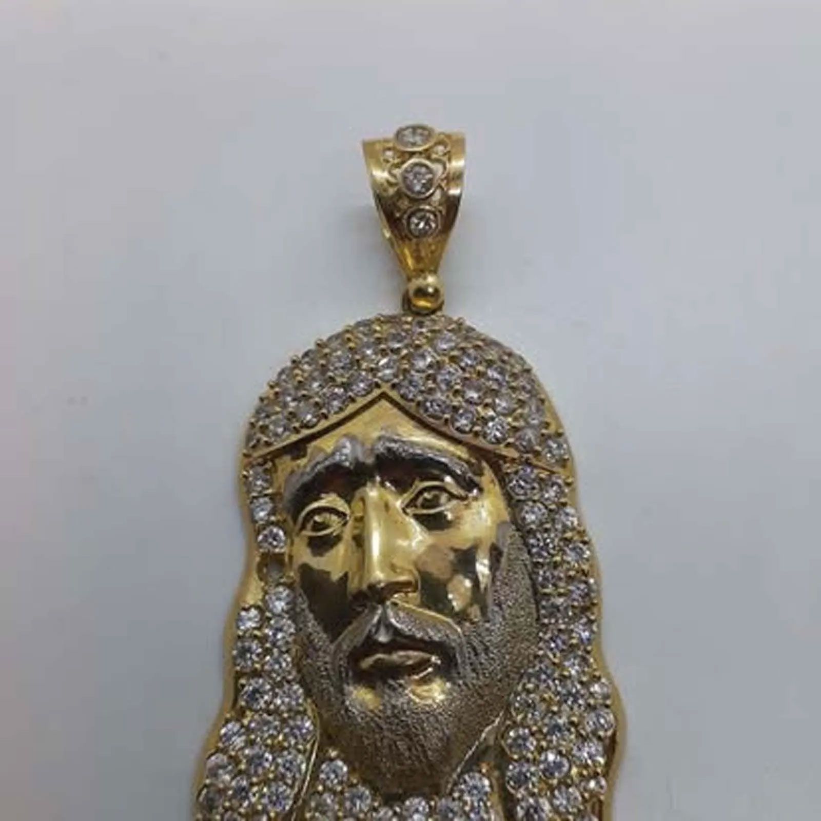 A gold pendant with a picture of jesus on it