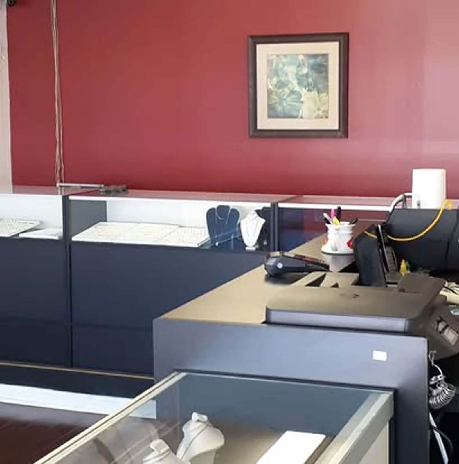 A jewelry store with a picture on the wall above the counter