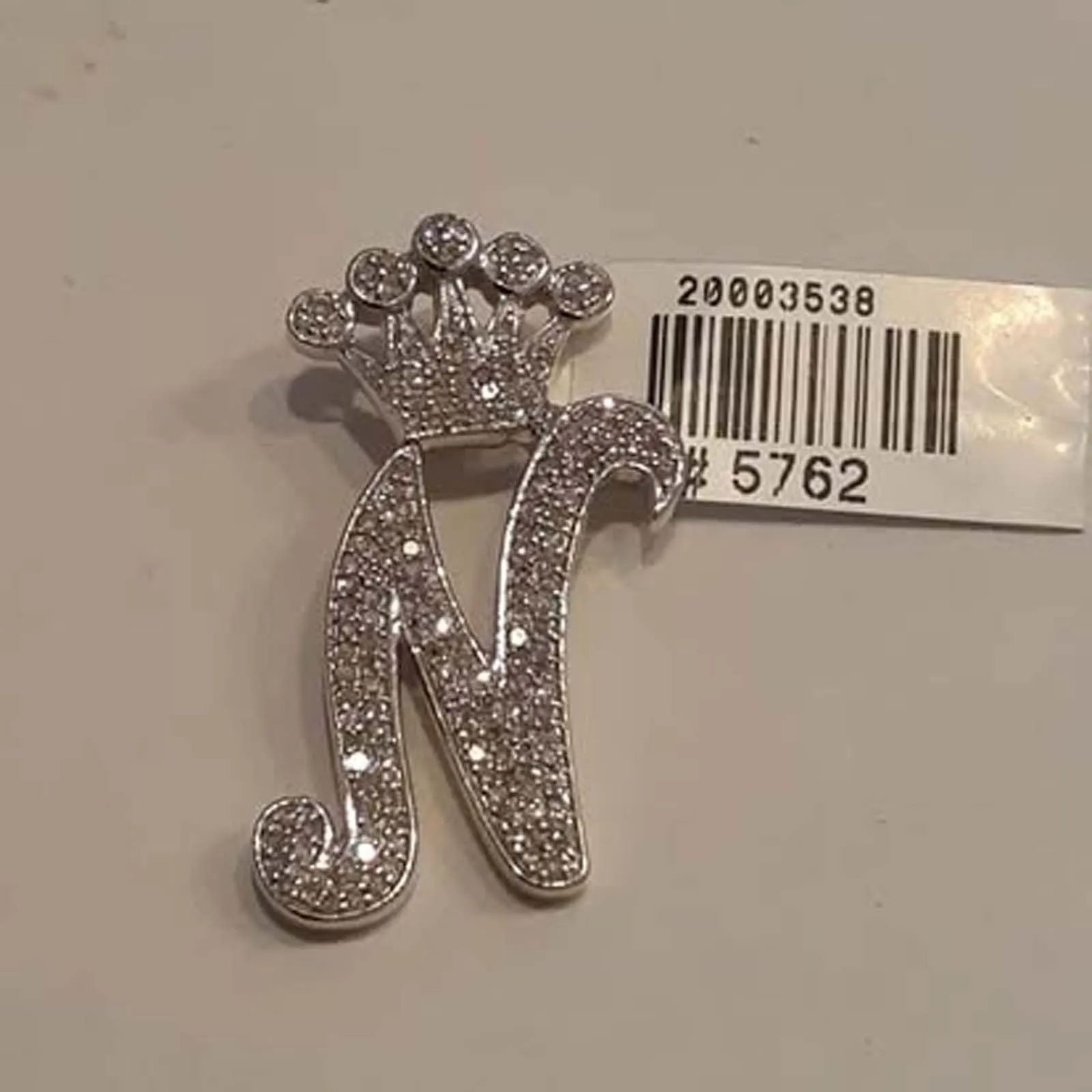 A brooch with the letter n and a crown on it