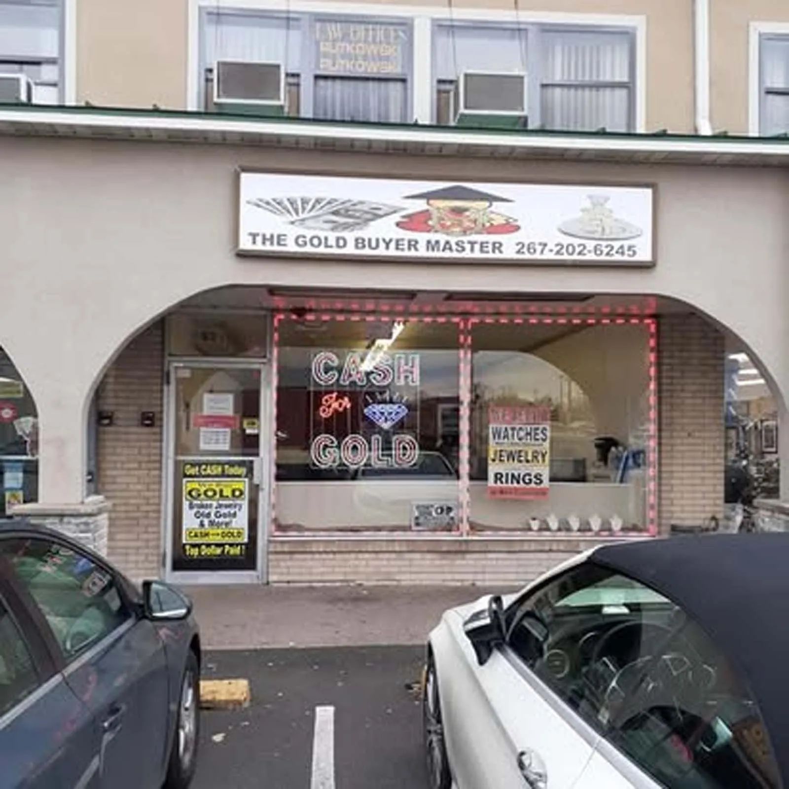 A car is parked in front of the gold buyer master