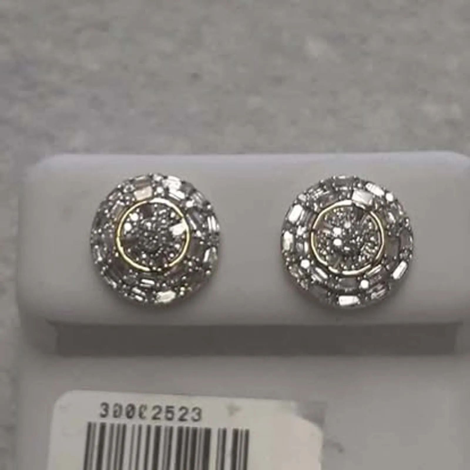 A pair of diamond stud earrings in a white box