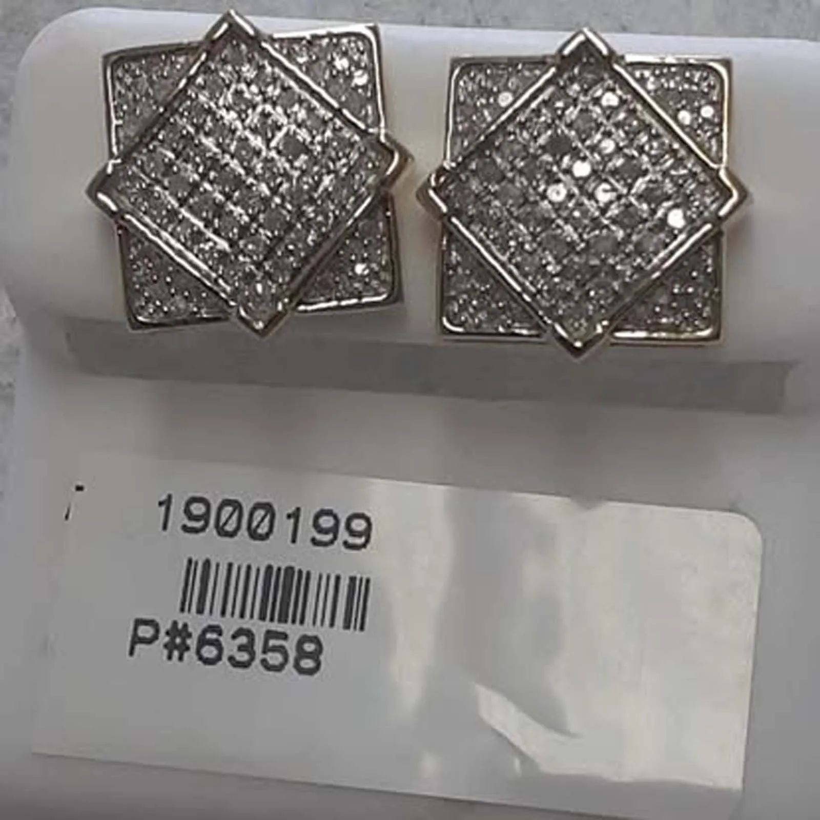 A pair of diamond stud earrings with a tag that says 1900199 p # 6358
