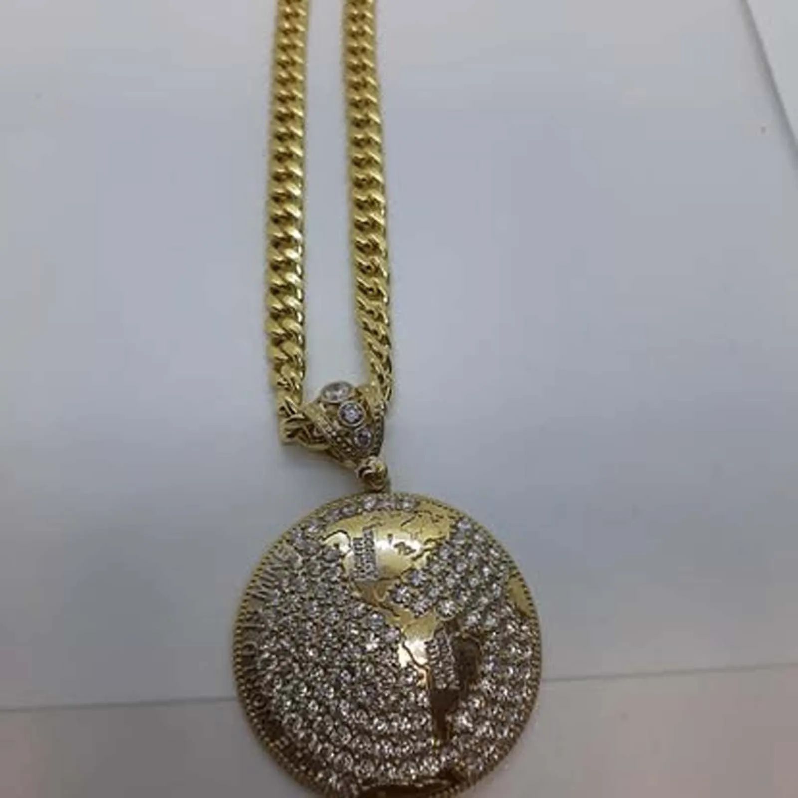 A gold necklace with a globe pendant on it