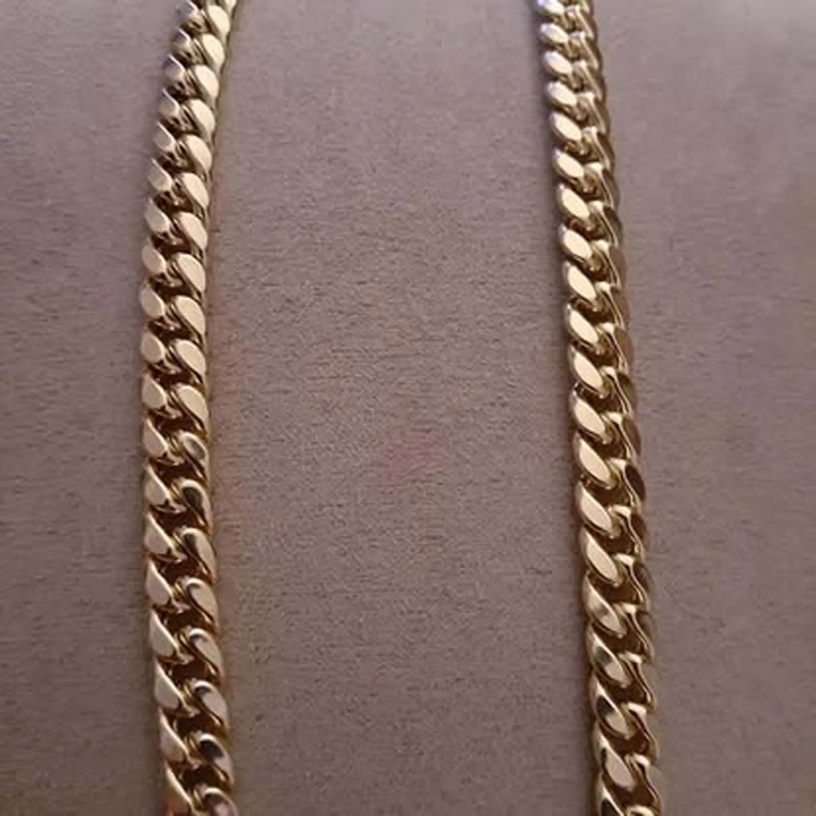 A close up of a gold chain on a table.