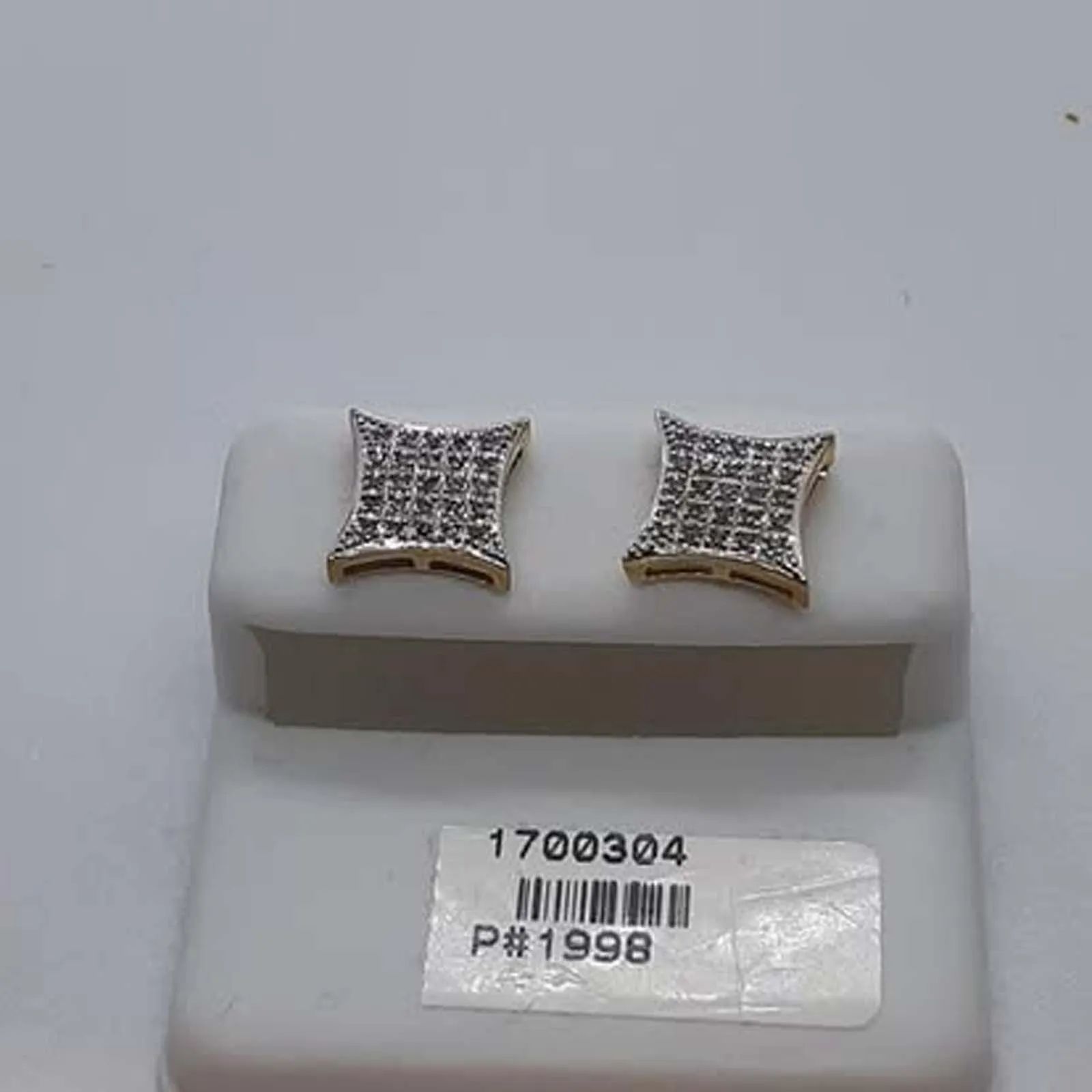 A pair of diamond stud earrings in a white box.