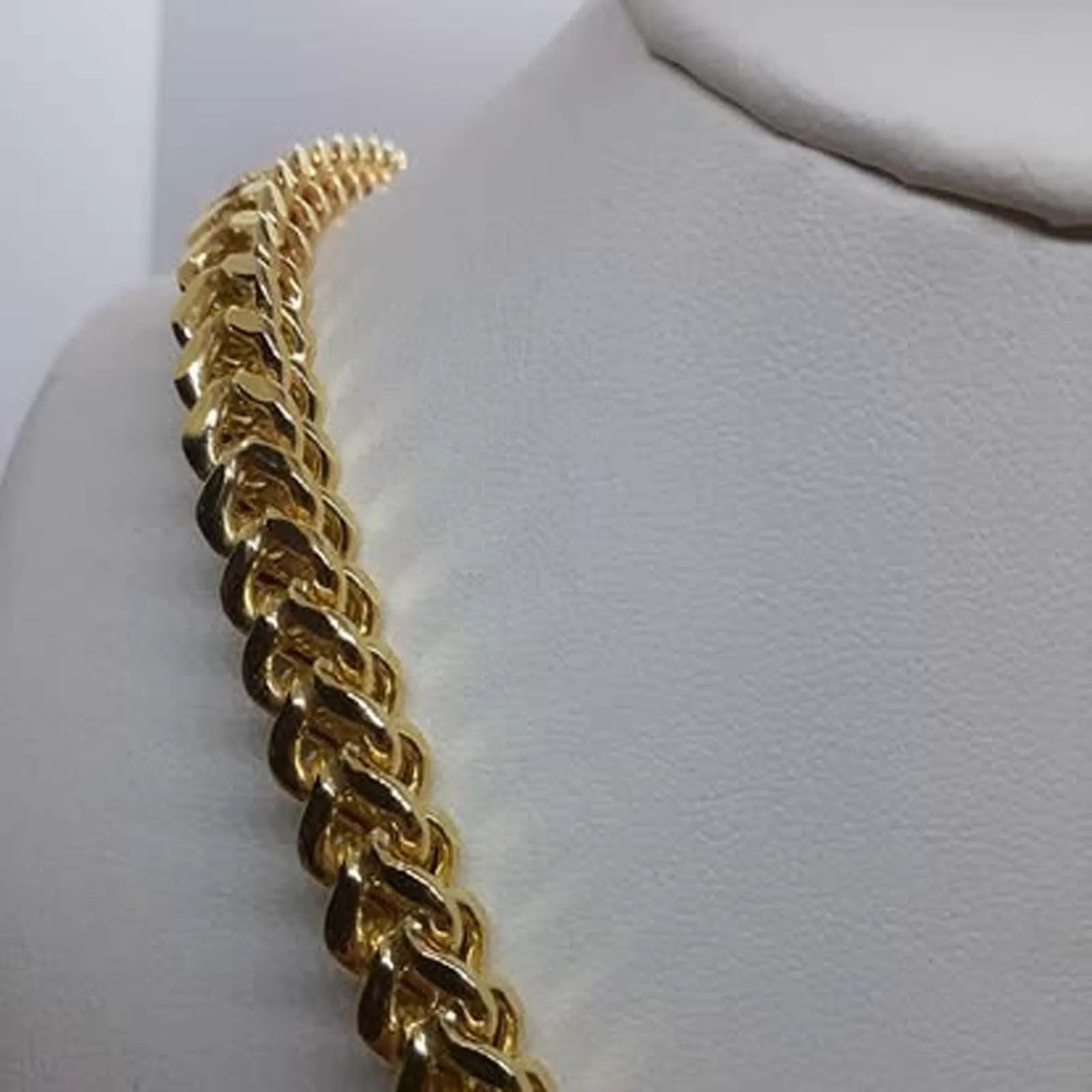 A close up of a gold chain on a mannequin