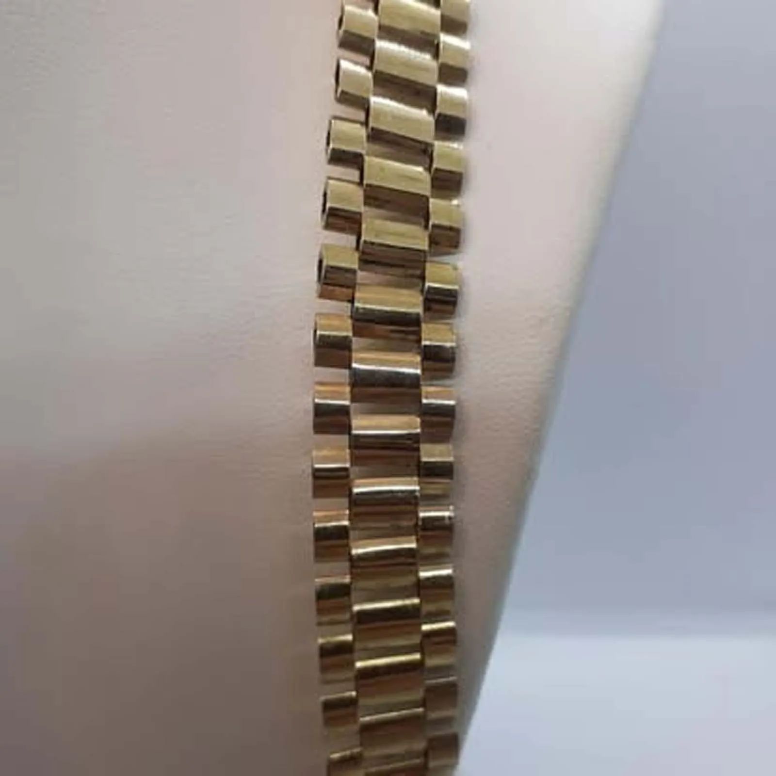 A close up of a gold bracelet on a person 's wrist.