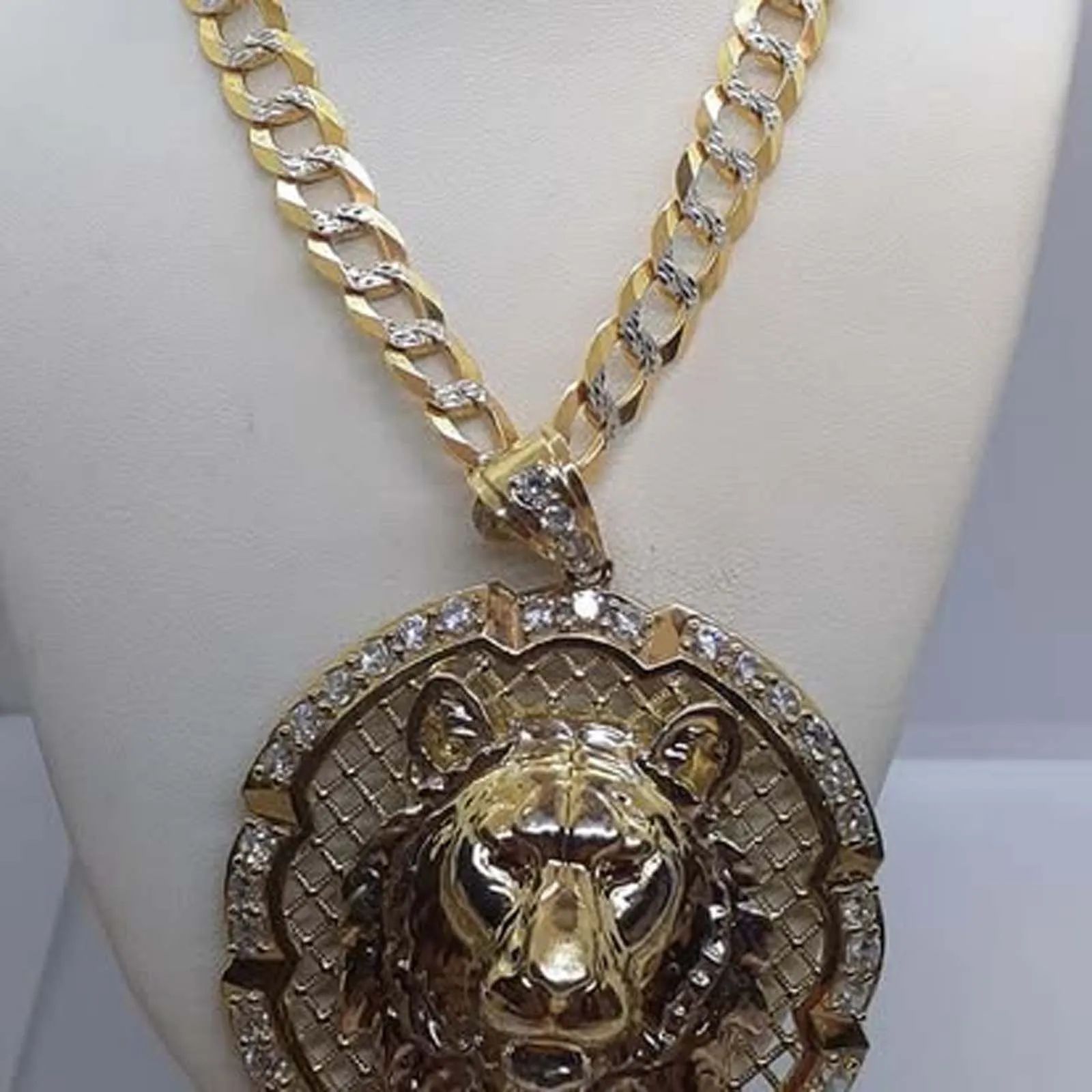 A gold chain with a lion pendant on it
