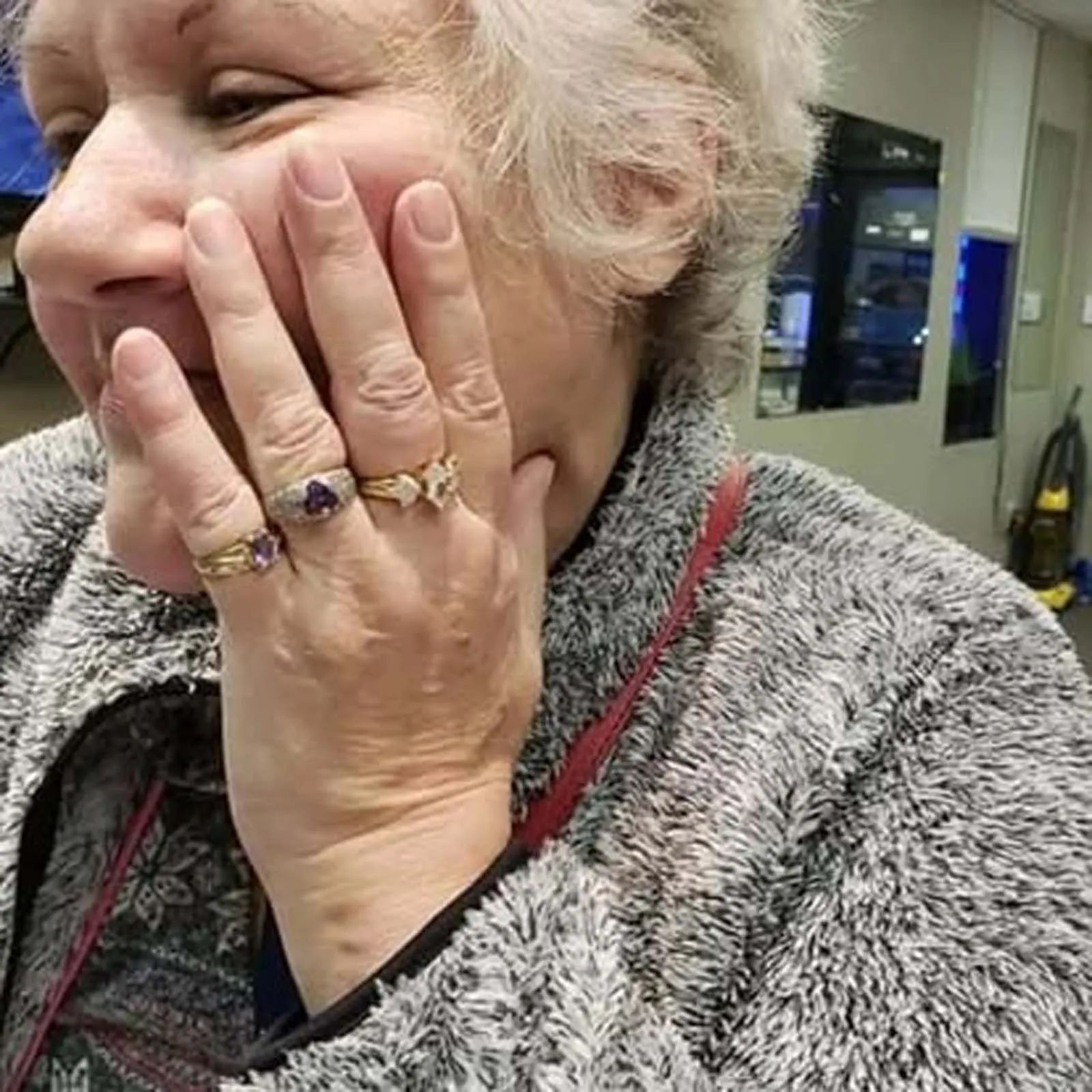 A woman is wearing three rings on her fingers.