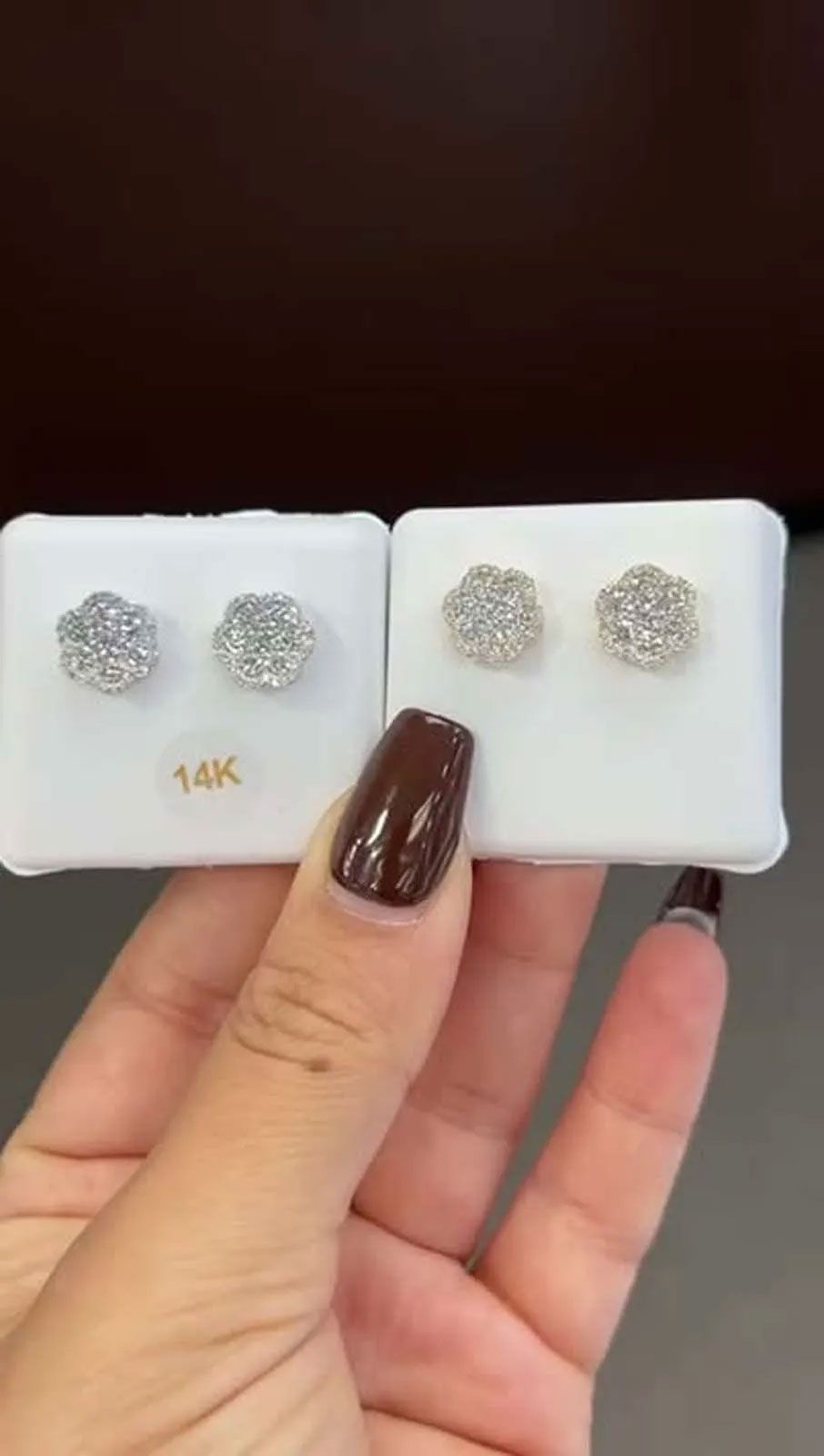 A person is holding a pair of earrings in their hand.