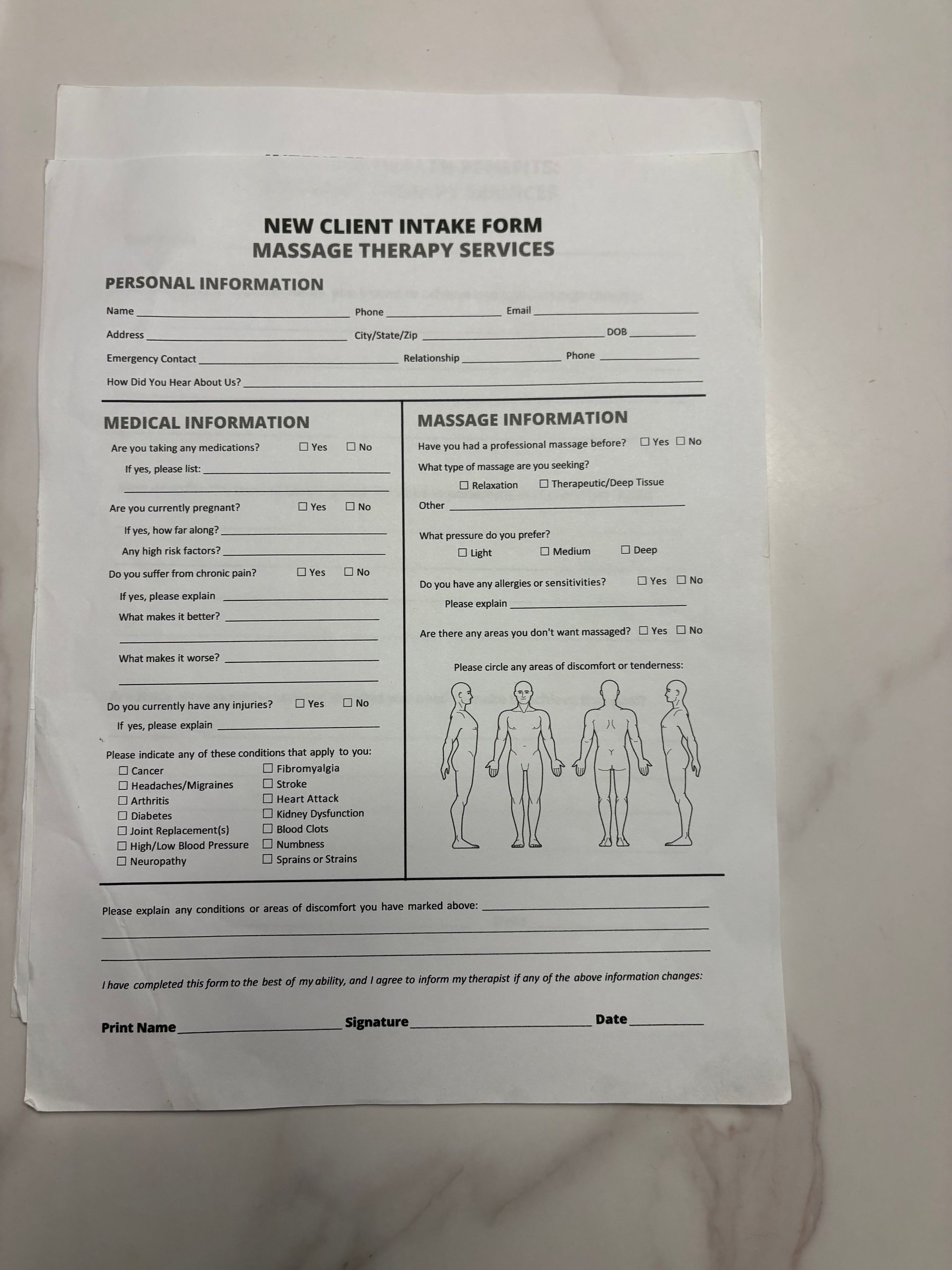 New Client Intake Form for Massage Therapy Services on a white surface.
