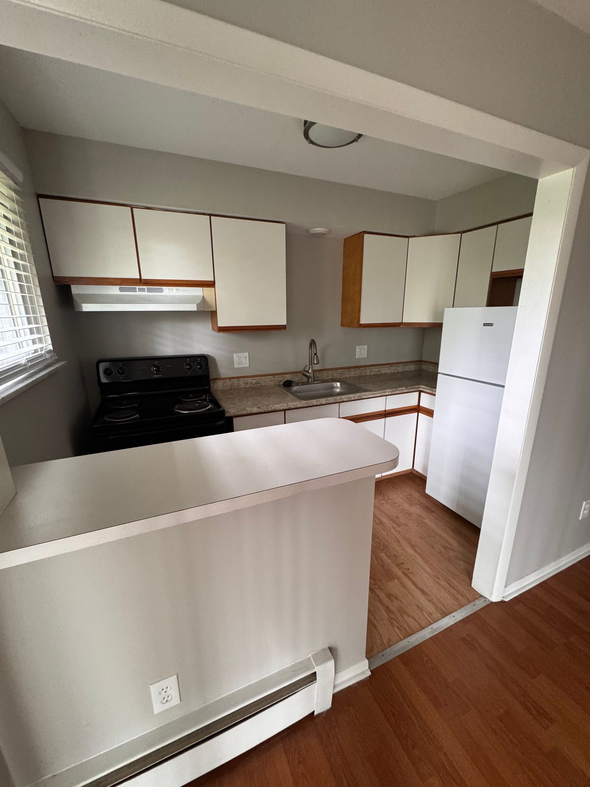 A kitchen with a stove and a refrigerator in it