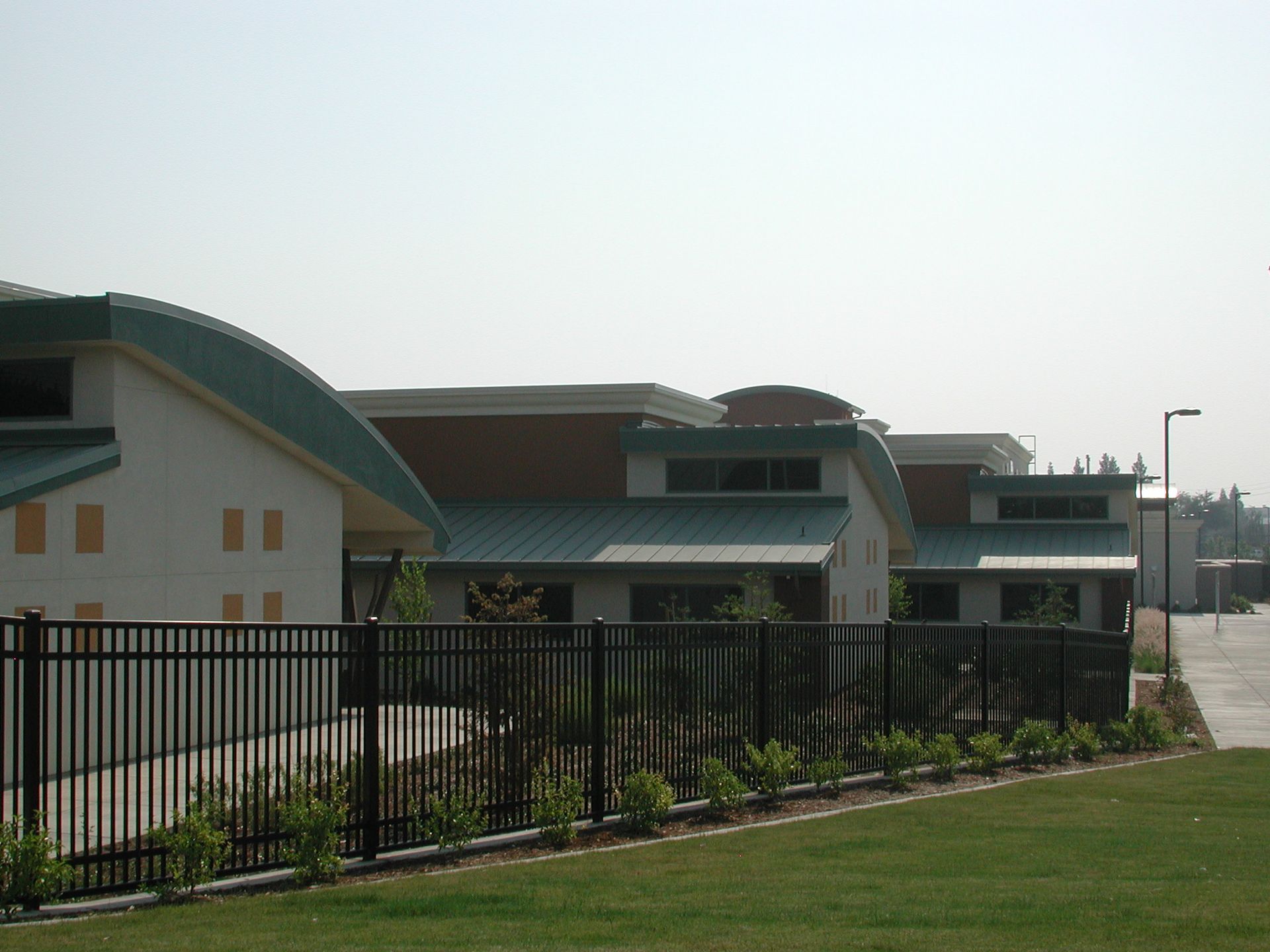 a fence surrounds a row of buildings on a sunny day