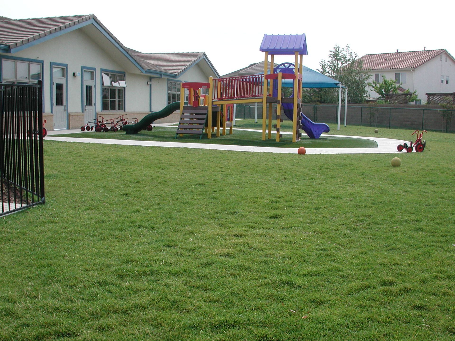 a fenced in yard with a playground in the background