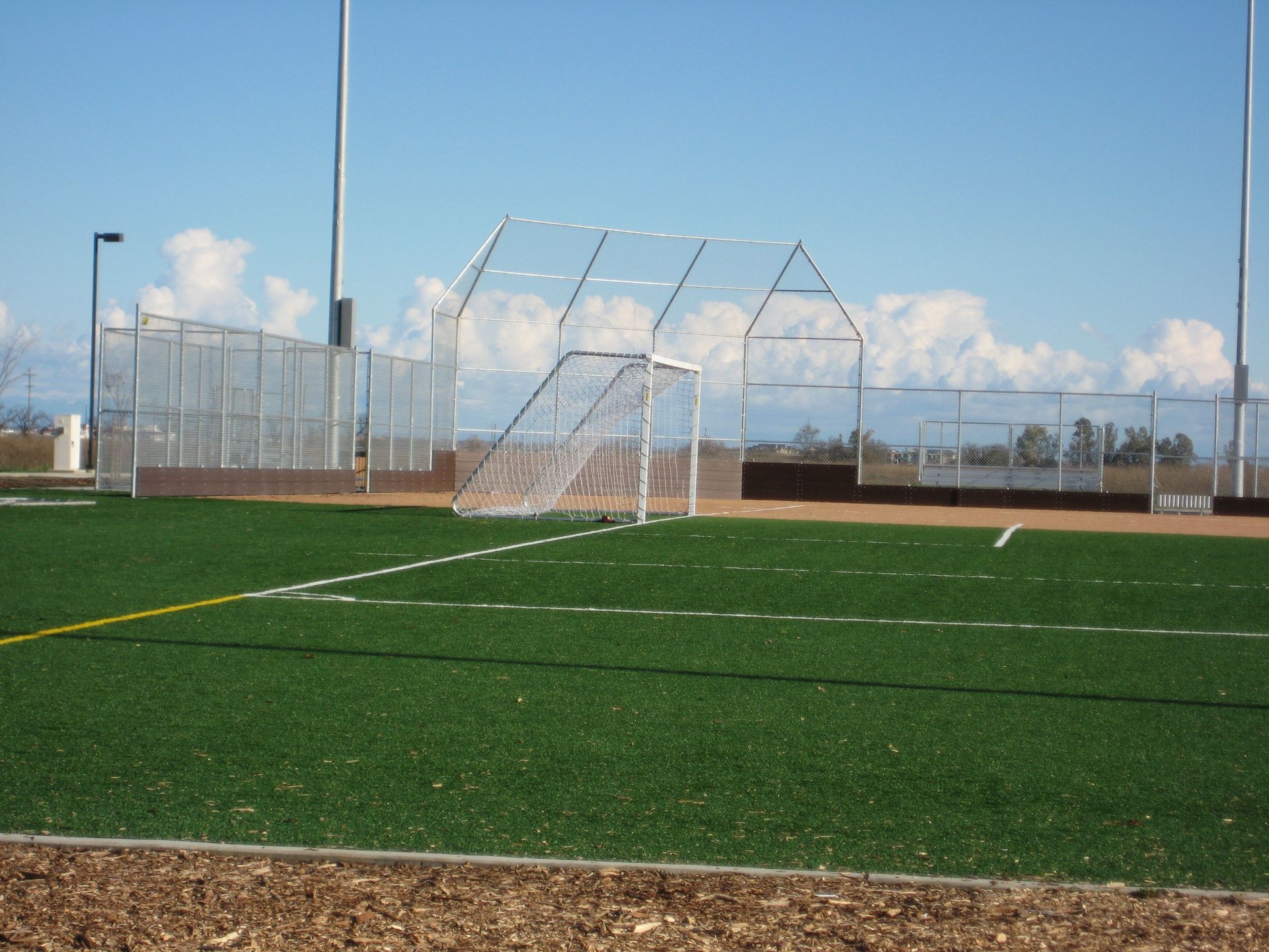 a soccer field with a fence and a goal