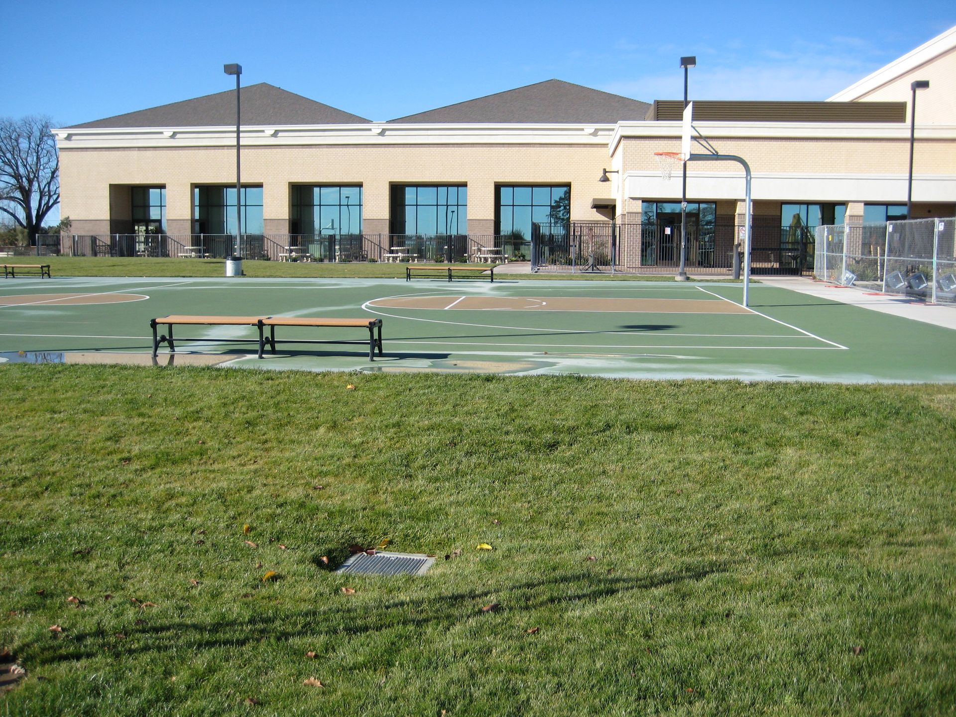 a large building with a basketball court in front of it