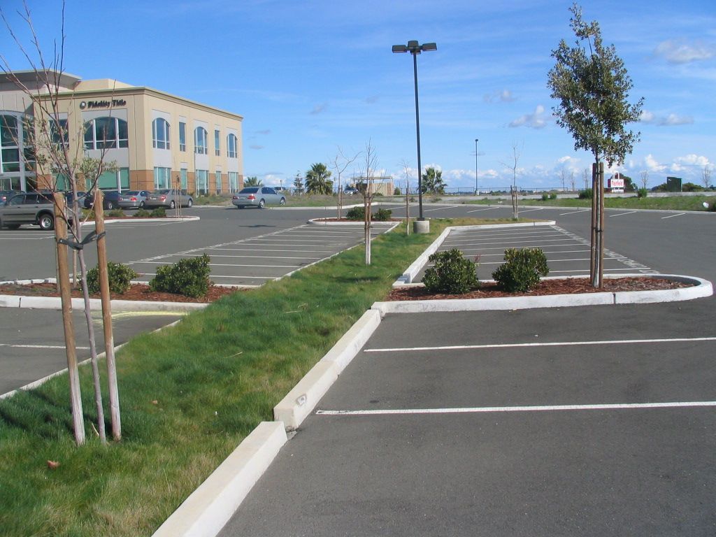 an empty parking lot with a building in the background