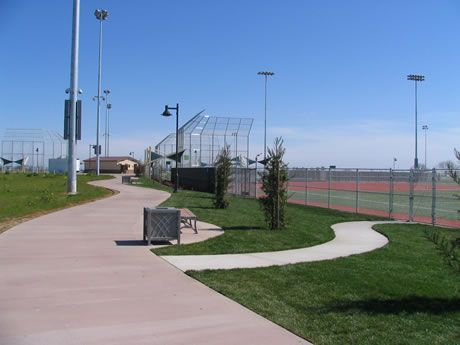 a path leading to a baseball field and tennis court