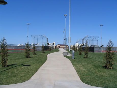 a concrete walkway leading to a baseball field