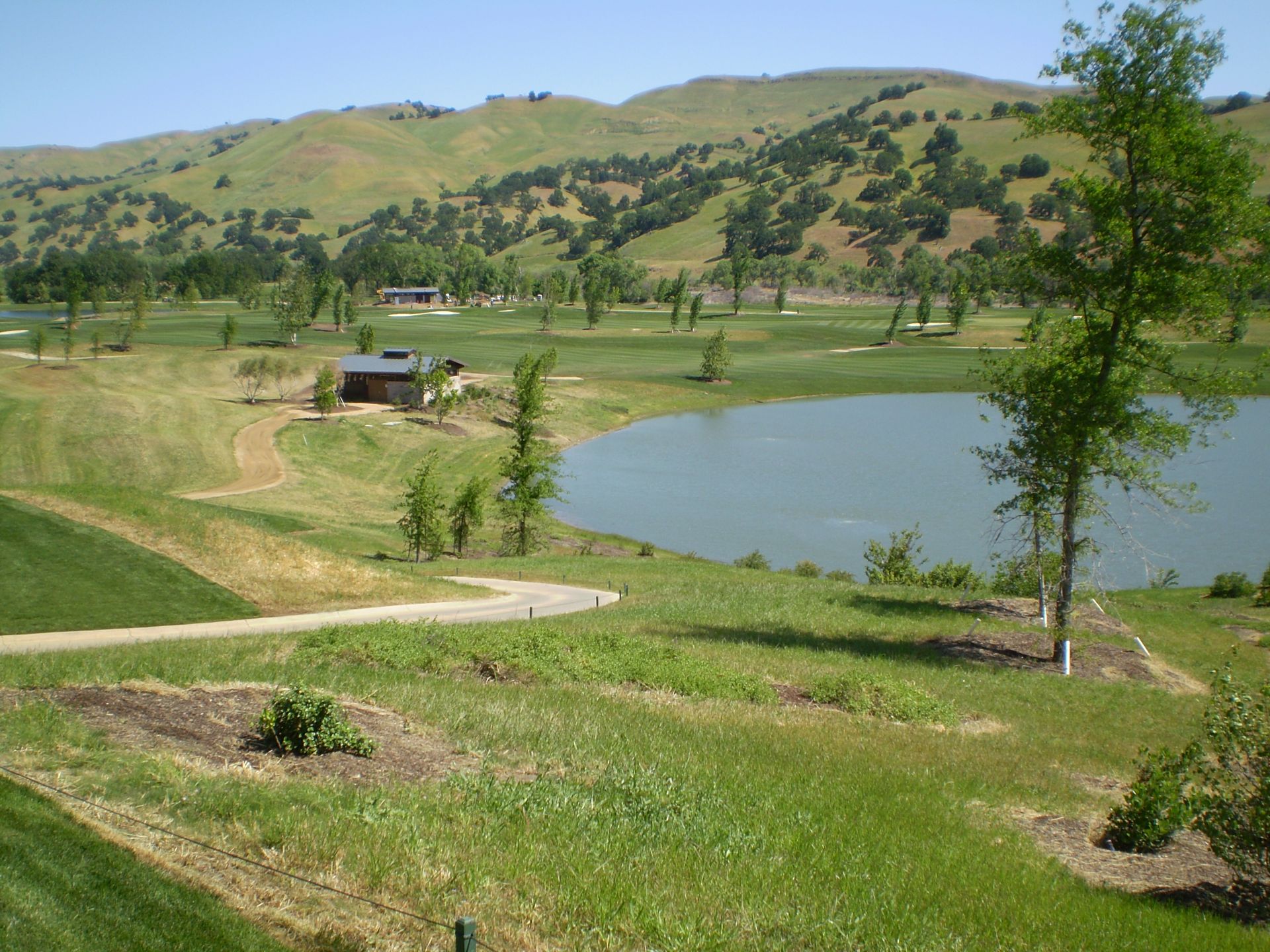 a golf course with a lake in the middle of it