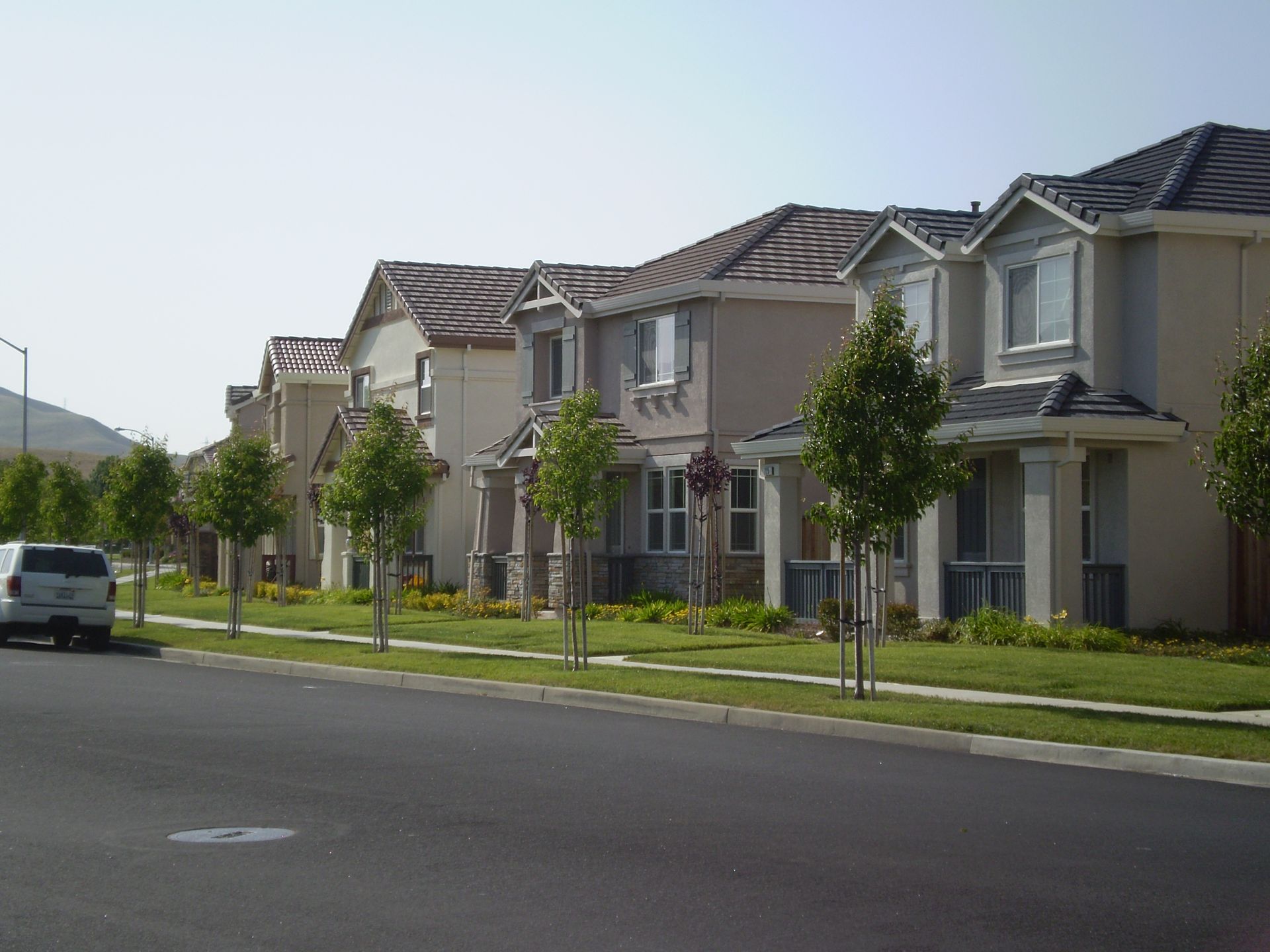 a white van is parked in front of a row of houses