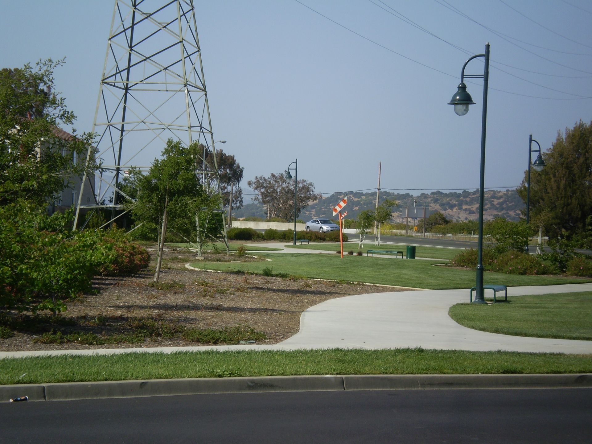 a park with a concrete walkway and a street light