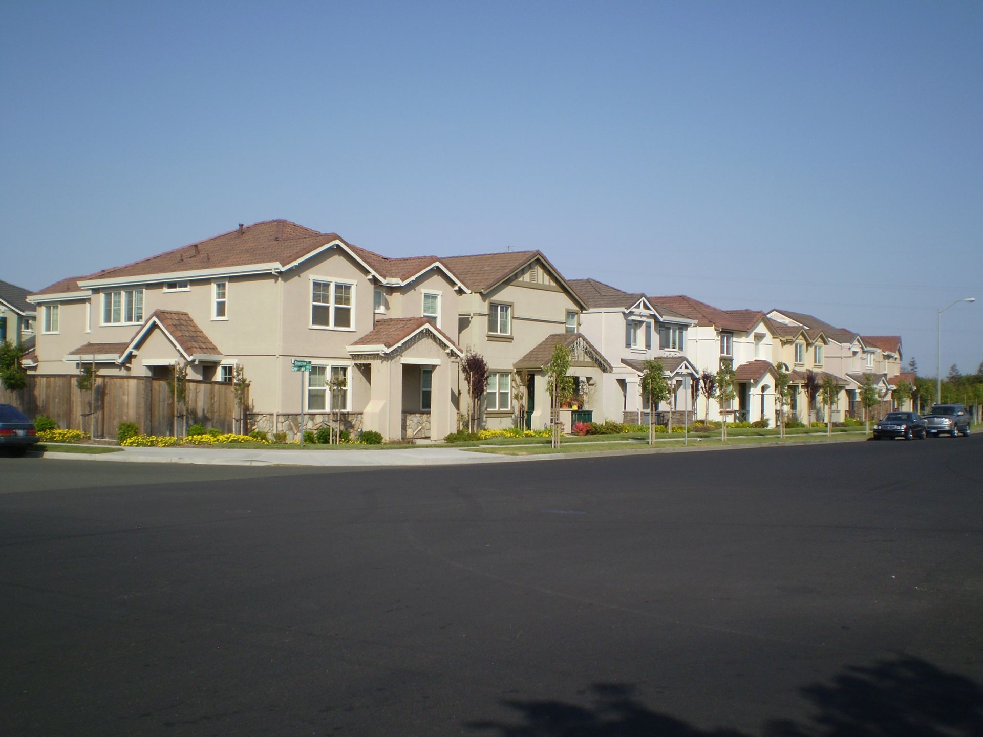 a row of houses with cars parked in front of them