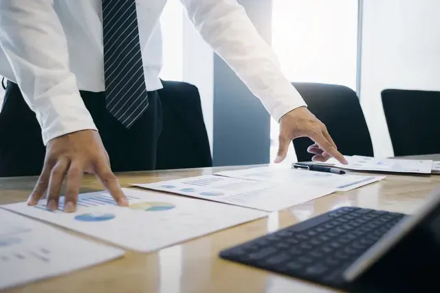 A man looks over his Buban Financial Portfolio documents and is happy to see growth