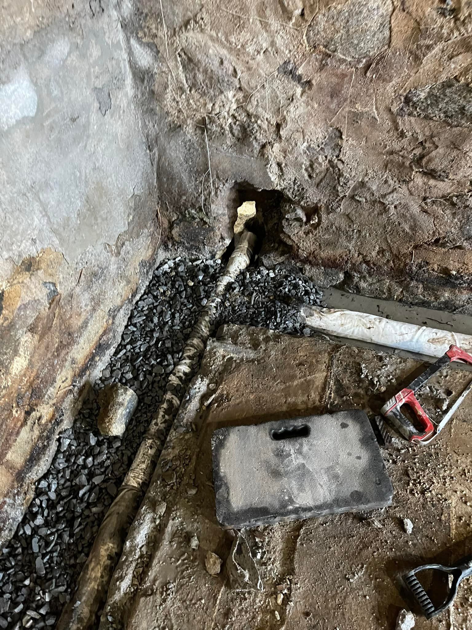 A pipe is coming out of a hole in the ground.