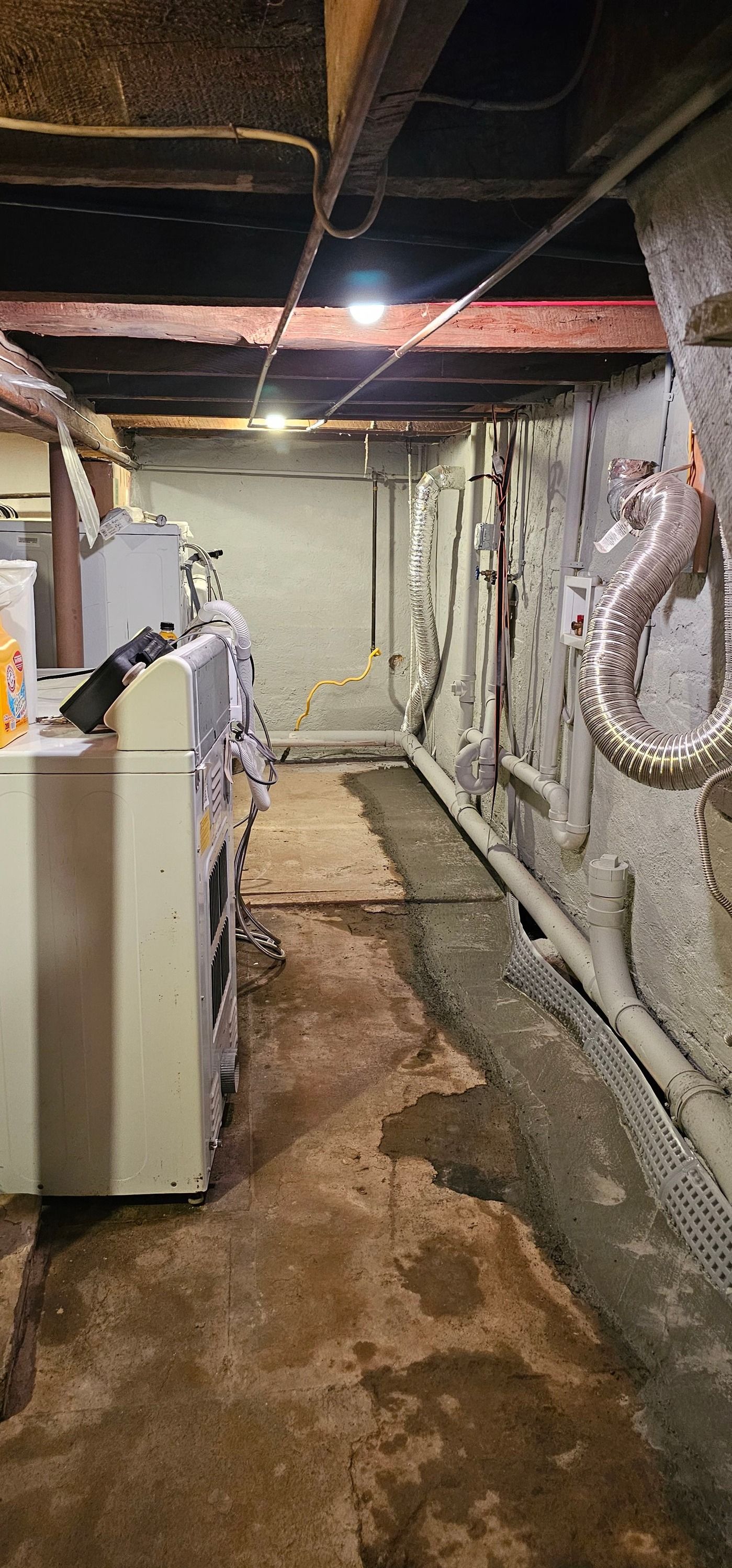 A laundry room in a basement with a washer and dryer.