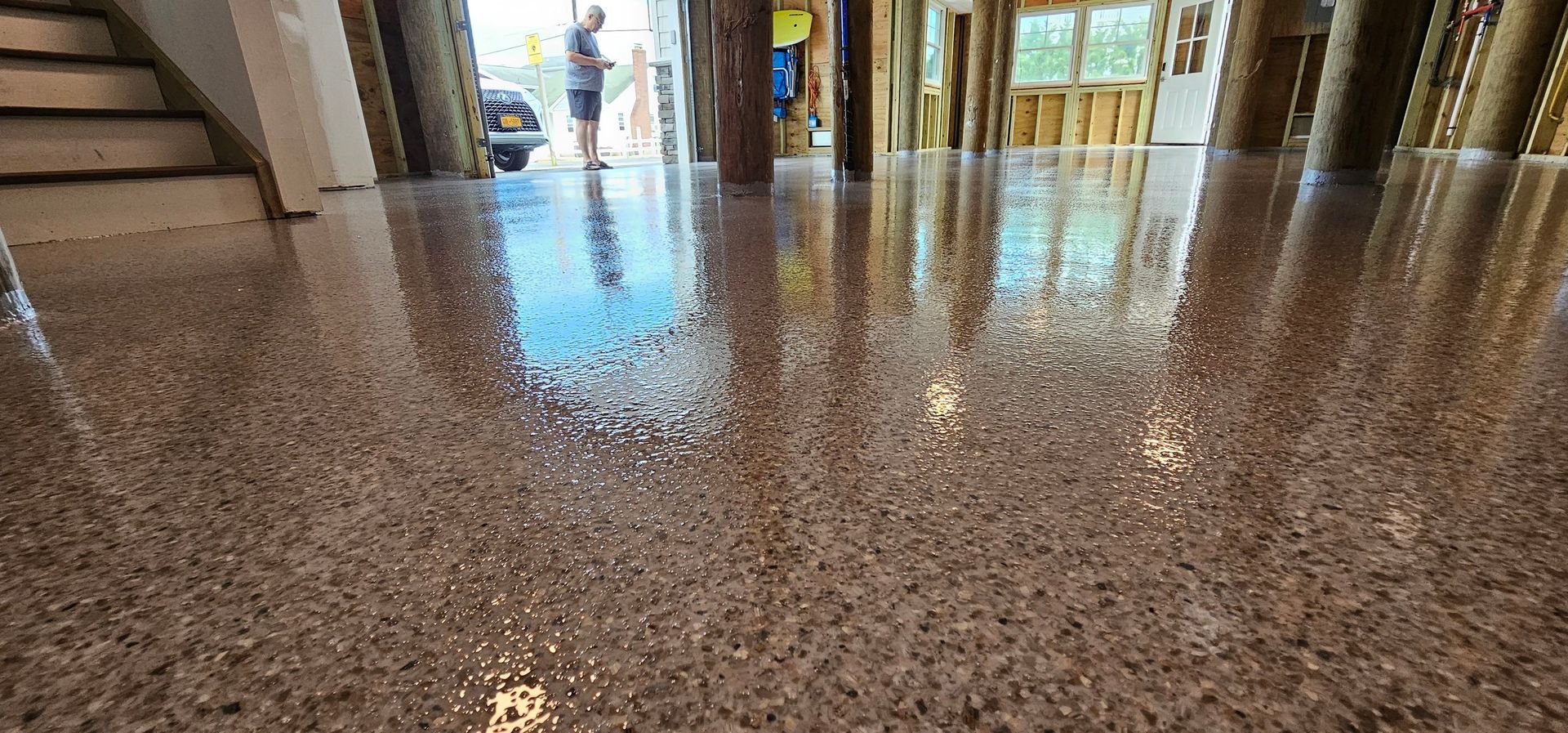 A shiny concrete floor in a room with stairs.