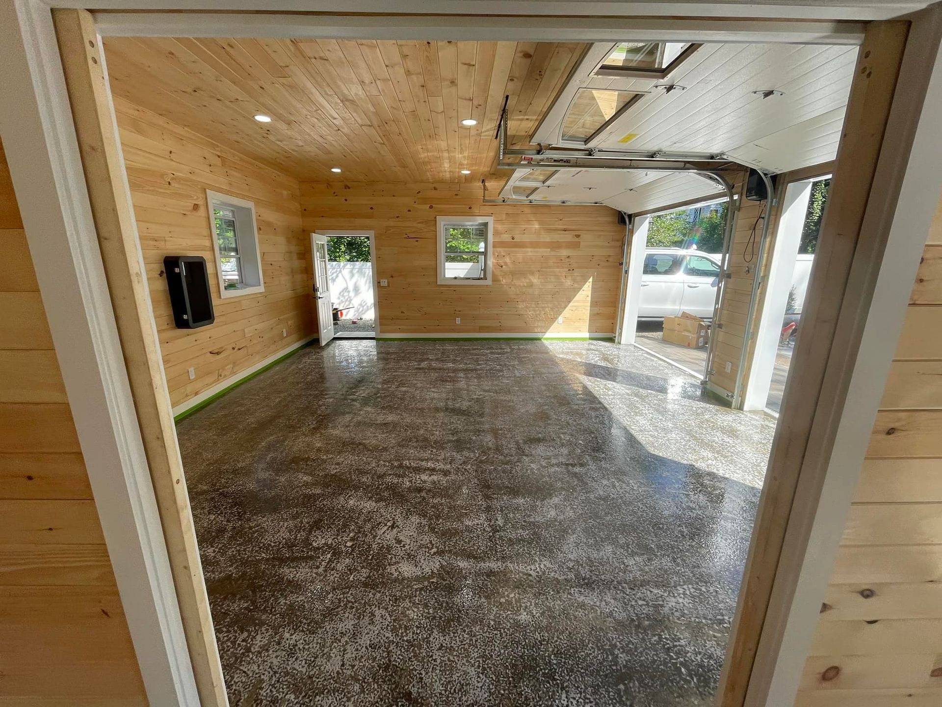 A garage with a concrete floor and wooden walls.