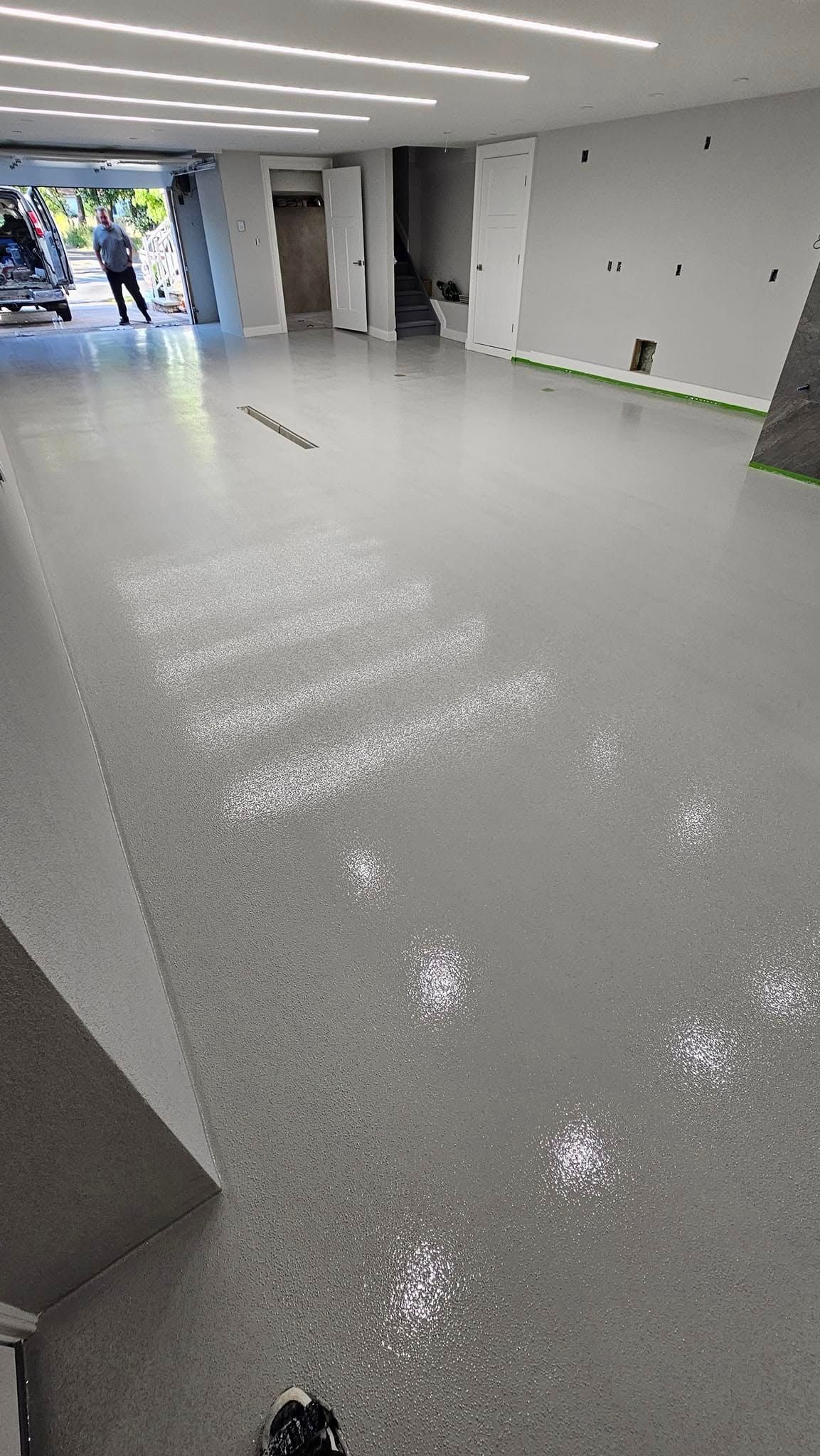 A large room with a concrete floor and stairs.