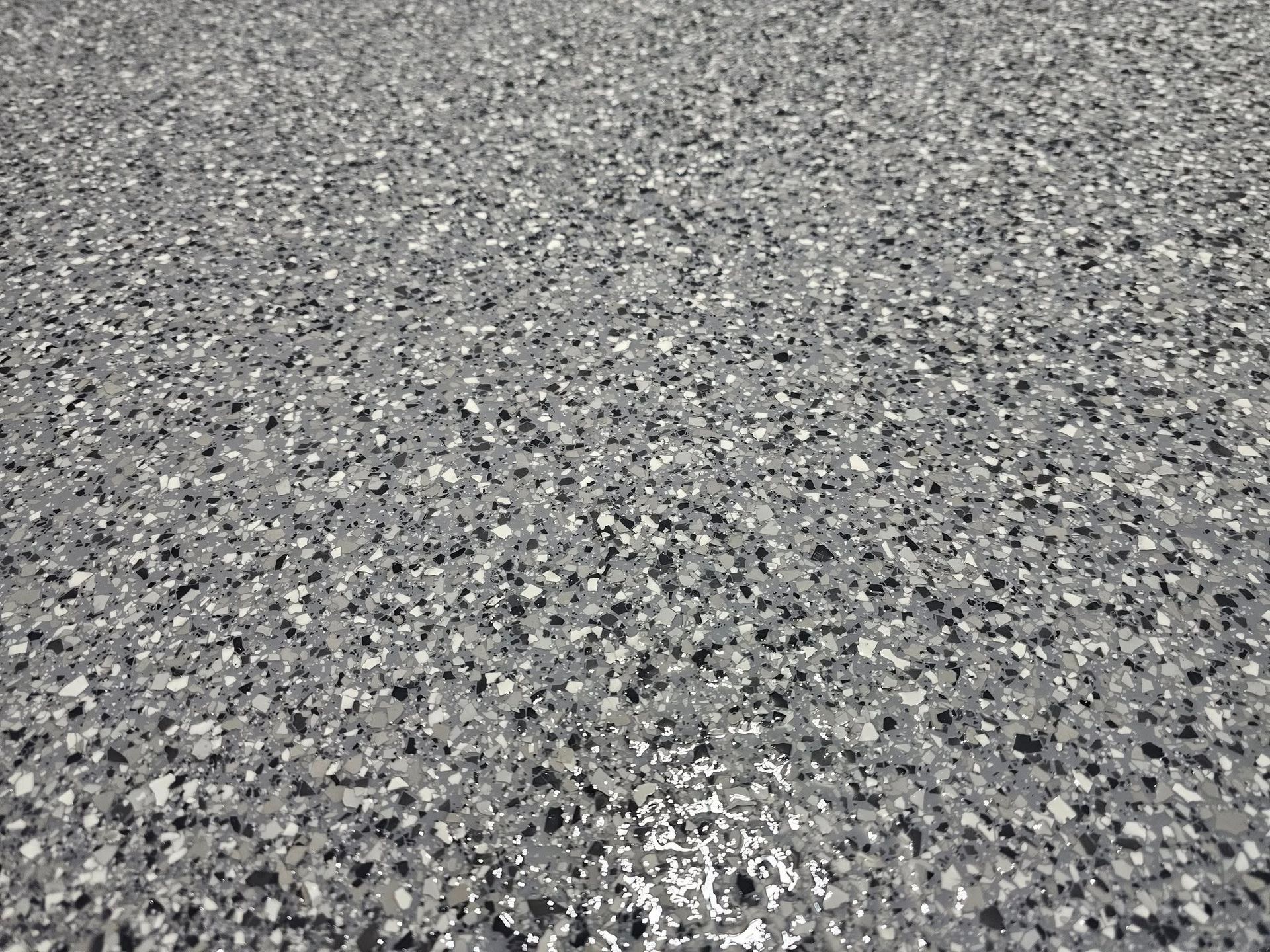 A close up of a gray and black concrete floor.