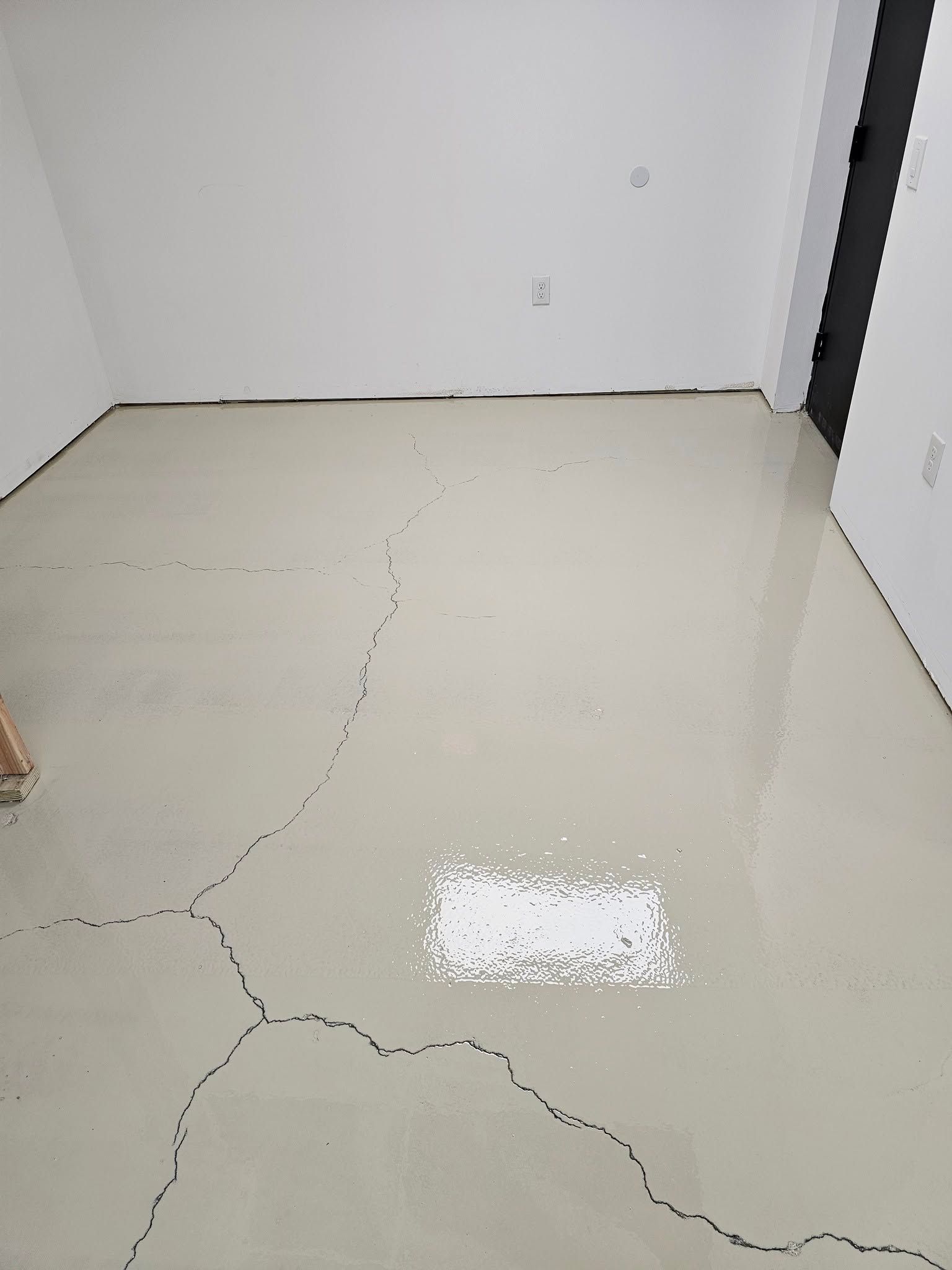 A room with a concrete floor and white walls.