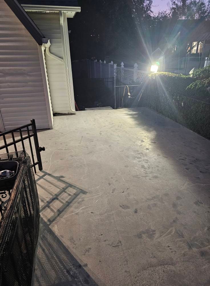 A concrete driveway leading to a house at night.